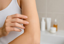 Kobieta z suchą skórą, w tle kosmetyki do pielęgnacji cery