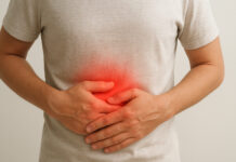 Mężczyzna trzymający się za brzuch, ma ból żołądka