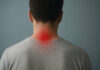 Mężczyzna tyłem, z widocznym punktem bólu w karku