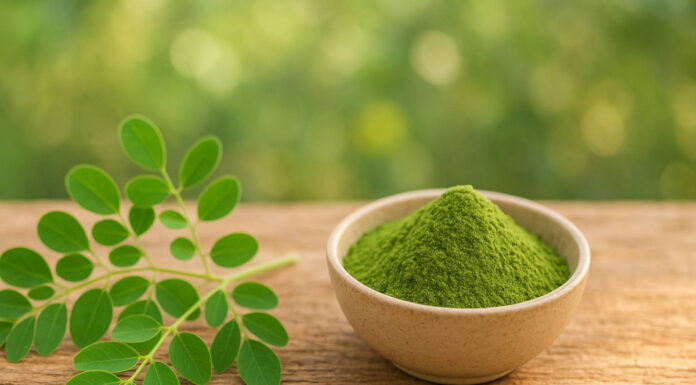 Moringa w formie liścia i proszku w miseczce, w tle wieś i natura