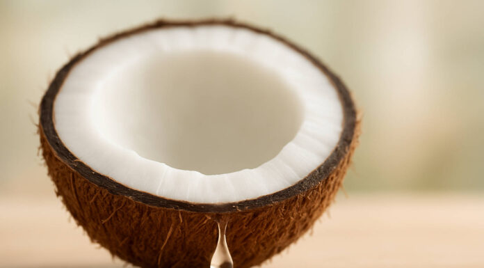 Symboliczna kropla olejku kokosowego wypływająca z kokosa