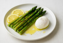 Talerz z grillowanymi szparagami na maśle, z jajkiem i plasterkami cytryny