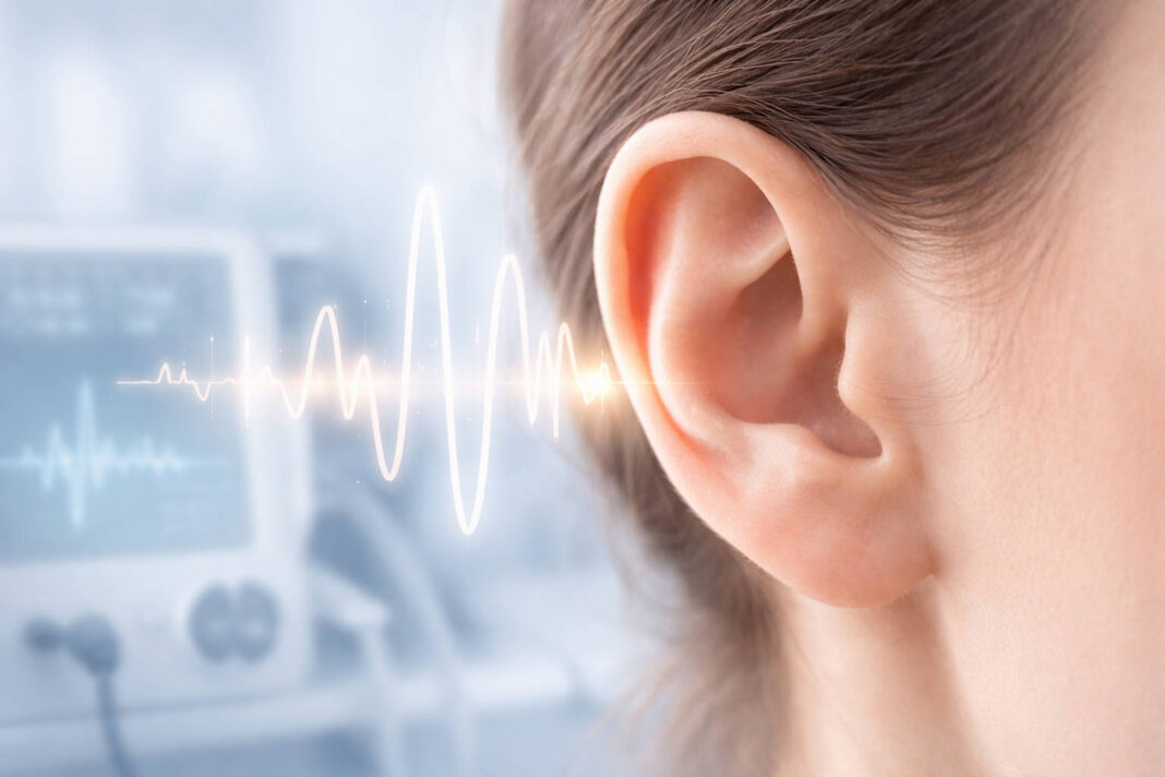 Zbliżenie na ludzkie ucho, w tle fale świadczące o szumach