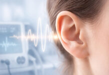 Zbliżenie na ludzkie ucho, w tle fale świadczące o szumach