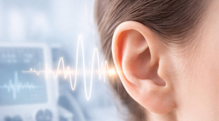 Zbliżenie na ludzkie ucho, w tle fale świadczące o szumach