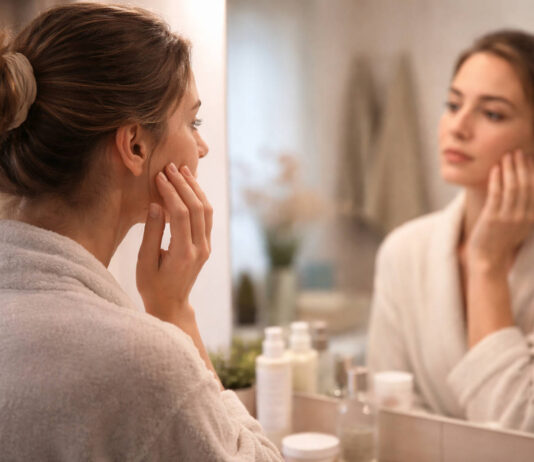 Kobieta przeglądająca się w lustrze w kontekście trądziku zapalnego