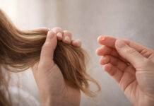 Kobieta trzymająca włosy, w kontekście ich wypadania - obok kropla suplementu (symbolicznie)