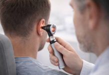 Lekarz badający ucho pacjenta otoskopem