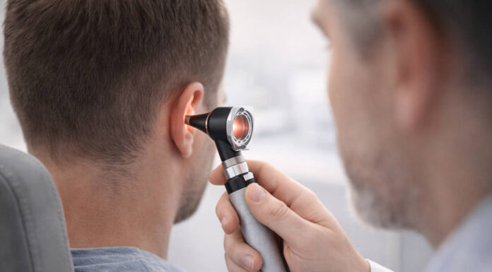 Lekarz badający ucho pacjenta otoskopem