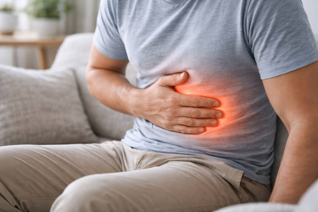 Mężczyzna trzymający się za brzuch, czerwona fala wskazująca ból, w kontekście wrzodów żołądka