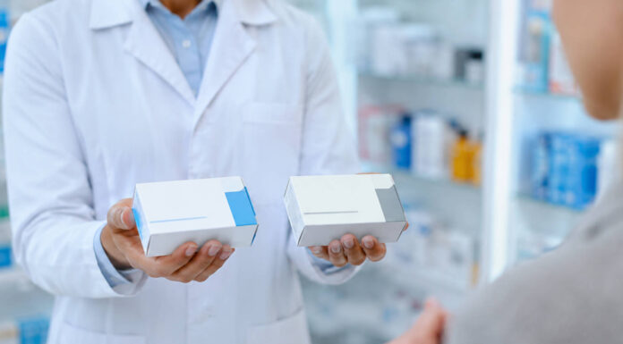 Farmaceuta trzymający w dłoniach dwa leki - oryginalny i generyczny. Grafika bez marek